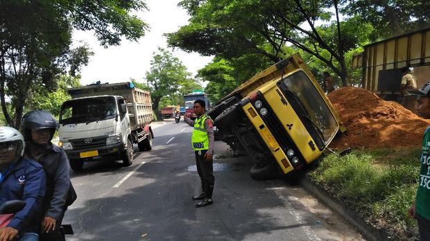 Truk Bermuatan Kayu Terguling Di Gresik