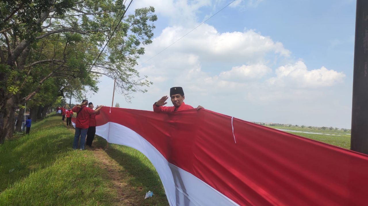 PDIP Lamongan Bentangkan Bendera Merah Putih 577 Meter di Waduk Jotosanur