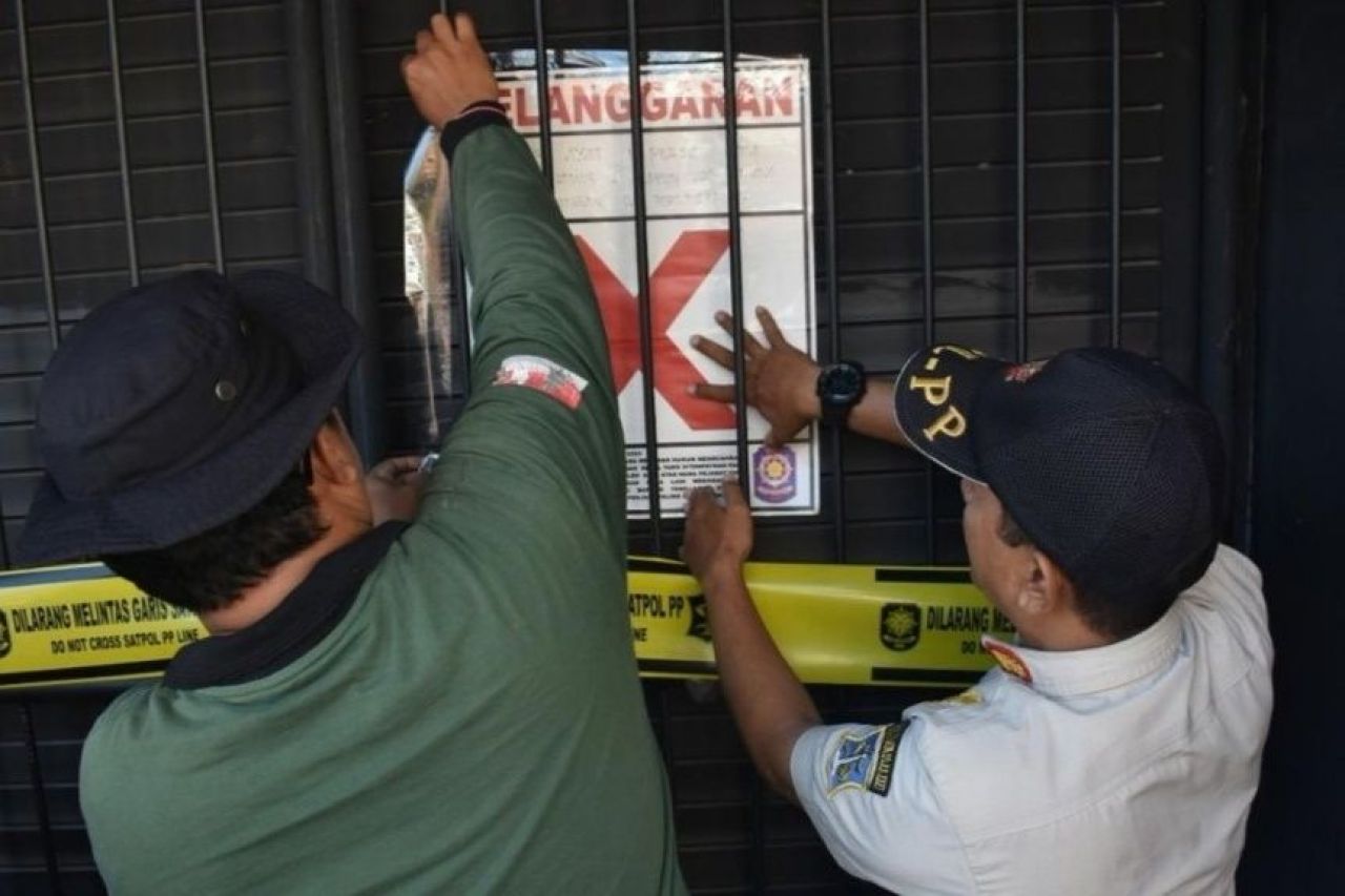 Petugas menyegel toko penjual miras. (Foto: Humas Pemkot Surabaya)